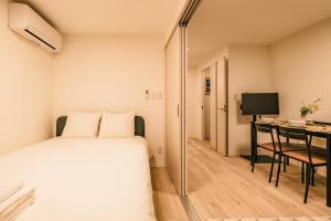 a bedroom with a bed and a desk with a computer at Apb 两国 in Tokyo