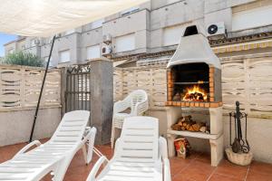 a patio with two chairs and a pizza oven at Hauzify I Casa Gala Placidia in Creixell