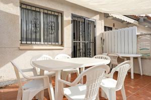 a white table and chairs in front of a building at Hauzify I Casa Gala Placidia in Creixell