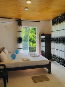 a large bed in a room with a window at Cinnamon garden villa in Weligama