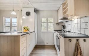 a kitchen with white cabinets and black counter tops at Holiday Home Froidal Rømø in Toftum