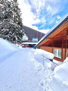 a building covered in snow next to a building at Tarbey - Studio au départ du télécabine Torrent in Leukerbad