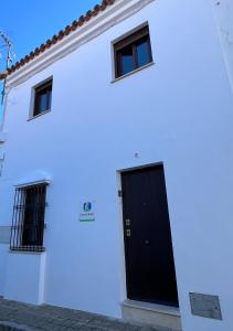 a white house with a black door at Casa Rural Aracena Bliss in Aracena