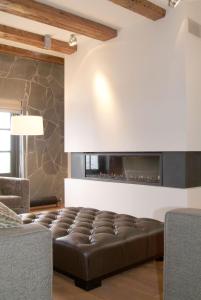 a living room with a leather couch and a fireplace at Texel Suites in Oudeschild