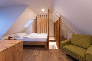 una camera da letto con un letto e una sedia in mansarda di Appartements Stuhleckblick a Spital am Semmering