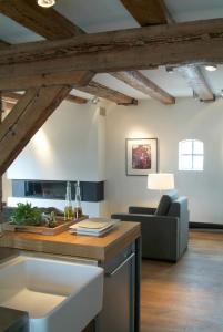 a kitchen and living room with wooden ceilings at Texel Suites in Oudeschild