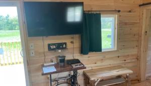 a room with a wooden wall with a desk at Black Bear Cabin in Black River Falls