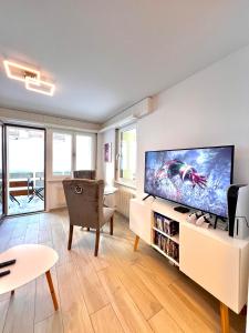 a living room with a large flat screen tv at Sandrina - Studio lumineux et rénové in Leukerbad
