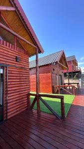 a wooden deck of a house with a building at Vista Encantada Complejo in Villa Carlos Paz +4 photos