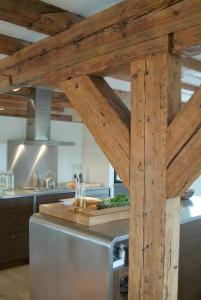 a kitchen with wooden beams and a stainless steel appliance at Texel Suites in Oudeschild