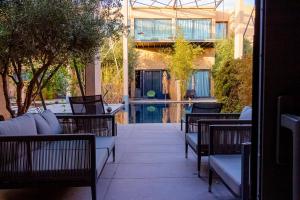 a patio with chairs and a pool in a building at Atelier Loft Oliver Palm Resort in Marrakesh