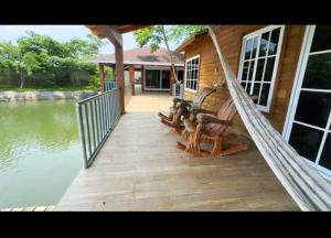 a porch of a house with a hammock next to the water at La Isla Ipala in San Isidro