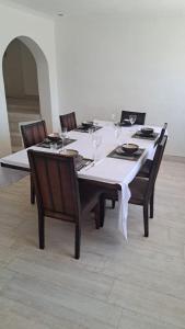 a table with chairs and a white table cloth on it at Gletwyn House Retreat in Harare in Helensvale