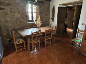 a dining room with a wooden table and chairs at Alma de Villuercas CR-CC-0070 in Cabañas del Castillo