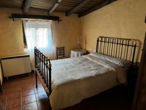 a bedroom with a bed in a room with a window at Alma de Villuercas CR-CC-0070 in Cabañas del Castillo