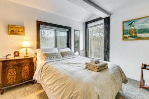 a bedroom with a large bed and a window at 11 Mi to Sugarbush Eclectic Ski House with Hot Tub! in Roxbury