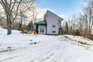 a house on a snowy road in the snow at 11 Mi to Sugarbush Eclectic Ski House with Hot Tub! in Roxbury