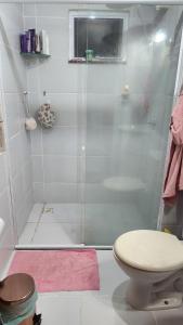 a bathroom with a shower with a toilet and a pink rug at Apt Mário Covas COP 30 in Belém