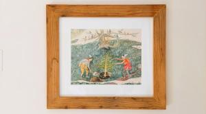 a framed picture of two people planting a tree at Ferienwohnung CAMANABODA in Camanaboda