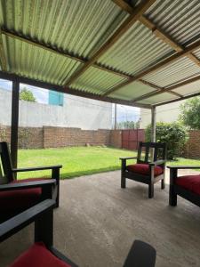 un patio con 2 sillas y toldo con césped en Casachica Navarro, en Navarro