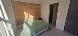 a small bedroom with a green bed in a room at Vivisierras, Duplex a estrenar con pileta privada centro Villa Carlos Paz, 3 dormitorios, 2 baños, vista in Villa Carlos Paz