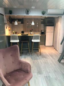 a kitchen with a chair and a counter with stools at Cozy Home Kanali, Preveza in Kanali +27 photos