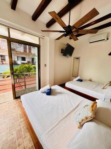 two beds in a room with a large window at Departamento 01 en el Centro de Holbox in Holbox Island