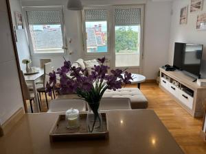 a living room with a vase of purple flowers on a table at El pisuco in Miengo