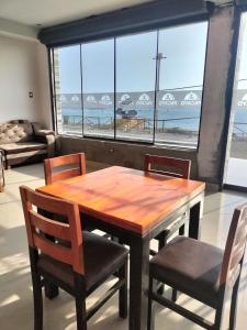 mesa de comedor con sillas y vistas a la playa en Paradisse, en Huacho