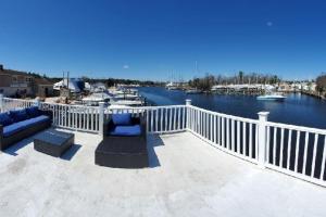 a balcony with a view of a harbor with boats at Float and Relax ON the Water Float Home in Forked River