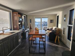 a kitchen and living room with a table and a couch at Panama Float Home Riverfront Fire Pit in Forked River