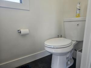 a white toilet in a bathroom with a roll of toilet paper at Panama Float Home Riverfront Fire Pit in Forked River