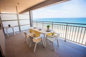 una mesa y sillas en un balcón con vistas al océano en Apartment Núria, en Bellreguart