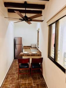 ホルボックス島にあるFlat in the middle of Holboxのキッチン(椅子2脚、テーブル、冷蔵庫付)