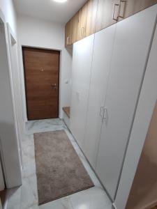 a hallway with white cabinets and a door at Stan na dan Sunce in Bijeljina