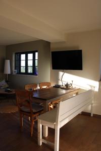 a living room with a table and a flat screen tv at Regina in Peso