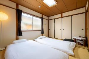 a bedroom with two beds and a window at 二条駅から徒歩10分 in Kyoto +108 photos