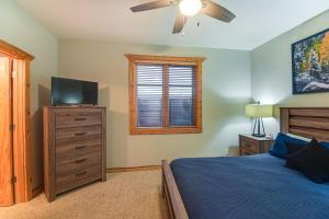 een slaapkamer met een bed en een flatscreen-tv bij Patio and Mountain Views Central Grand Lake Condo! in Grand Lake