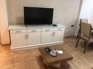 a flat screen tv sitting on top of a white cabinet at Peppy Tower 1190 in Posadas