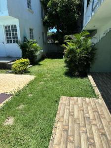 ein Hof eines Hauses mit Gras und Pflanzen in der Unterkunft Residences Les Loisirs in Grand Baie