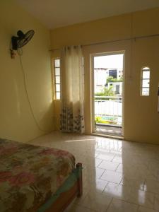 ein Schlafzimmer mit einem Bett und einer Tür mit einem Fenster in der Unterkunft Residences Les Loisirs in Grand Baie