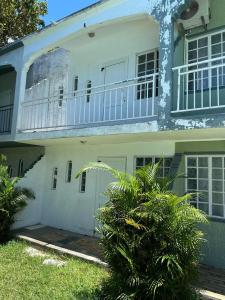 ein weißes Haus mit einem Balkon darauf in der Unterkunft Residences Les Loisirs in Grand Baie