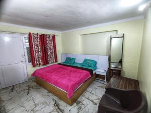 奈尼塔尔JK Guest House的卧室里有一张床、一面镜子和一把椅子 更多4张照片