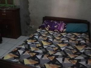 - un lit avec une couette colorée dans l'établissement Homestay Syariah Sederhana, à Sleman
