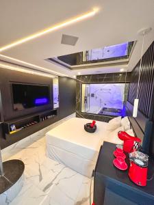 Un dormitorio con una gran cama blanca y un televisor. en Shopping Motel, en Castanhal 22 fotos más