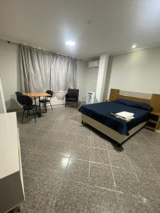 Un dormitorio con una cama y una mesa y sillas. en Suite 203 - Ed Toffano, en Cachoeiro de Itapemirim 2 fotos más