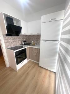 eine Küche mit einem weißen Kühlschrank und Holzböden in der Unterkunft Two Bedroom King Suite IH19 in Esenyurt