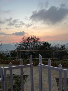 a white fence with a sunset in the background at JijiVisha in Kīar