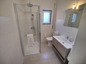 a bathroom with a shower and a toilet and a sink at A Casa das Tias in Benedita +18 photos