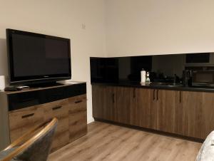 salon z telewizorem z płaskim ekranem i drewnianą szafką w obiekcie Apartament Bastion Wałowa Gdańsk w Gdańsku